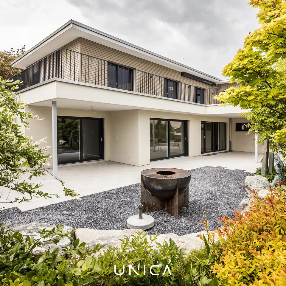 Umgebauter Aussenbereich mit überdachter Terrasse, Feuerstelle und Kiesgarten