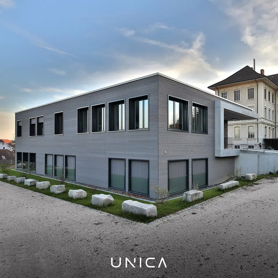 Öffentlicher Bau mit Parkplätzen und klarer moderner Architektur